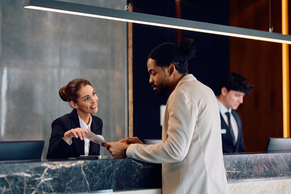 black man checking into or out of a hotel looking at bill