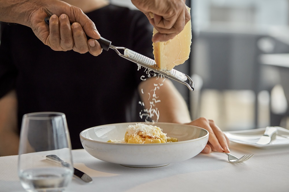 Chef on Explora Journeys grating parmesan