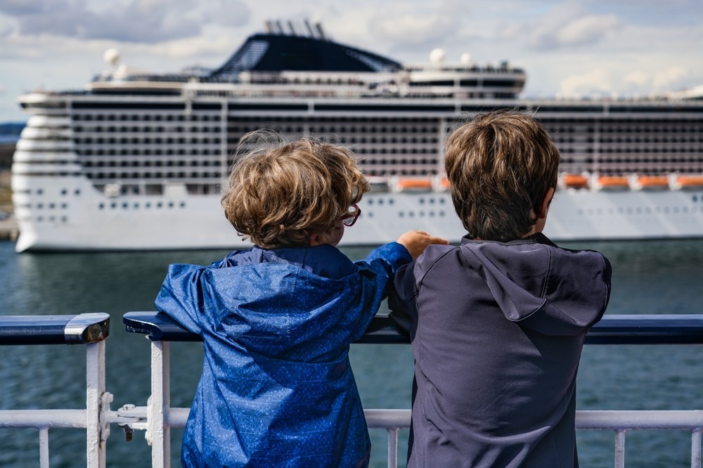 kids watching cruise ship pass by