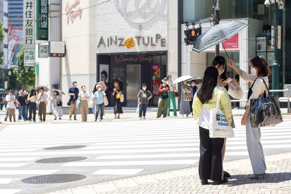 residents of Tokyo battling heat with umbrellas