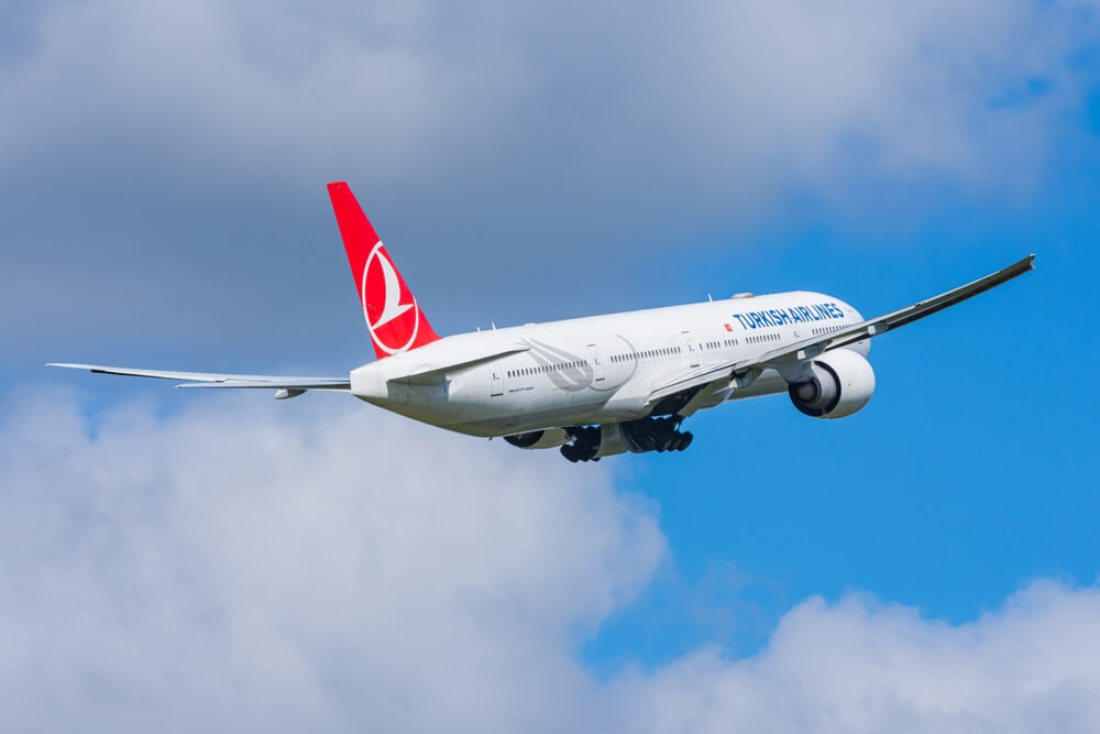 Turkish Airlines plane flying on a sunny day