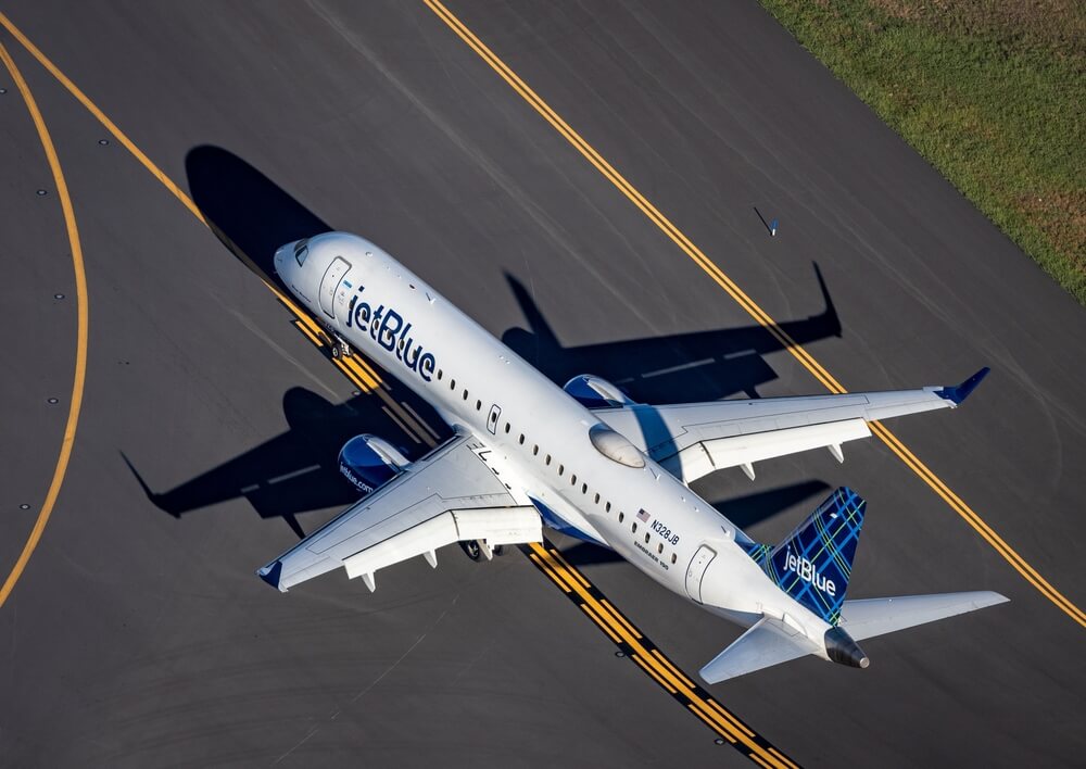 An aerial photograph of a Jetblue Airways Embraer 190 taxiing at an airport in Boston